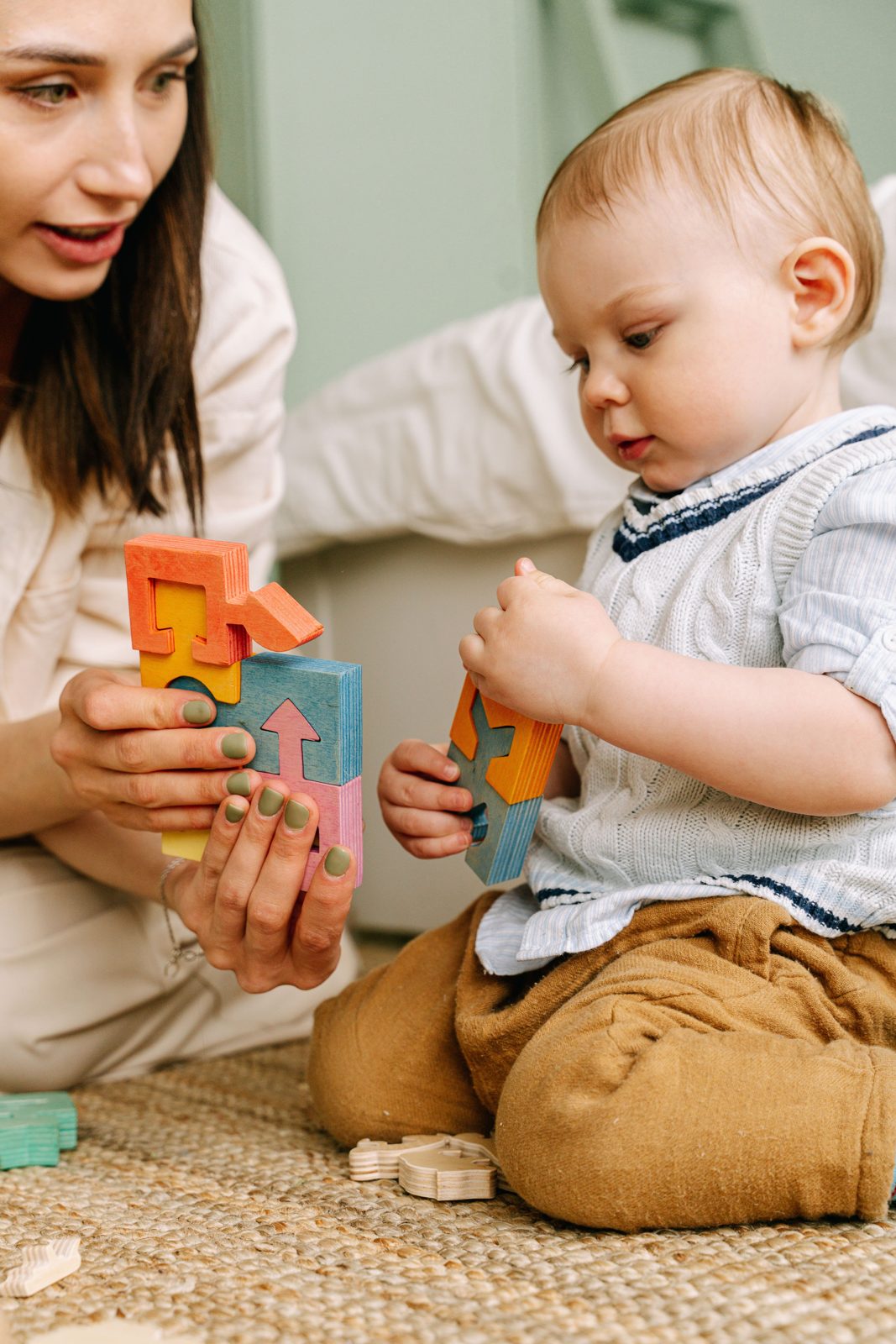 Mother playing with her baby son and colourful stacking blocks